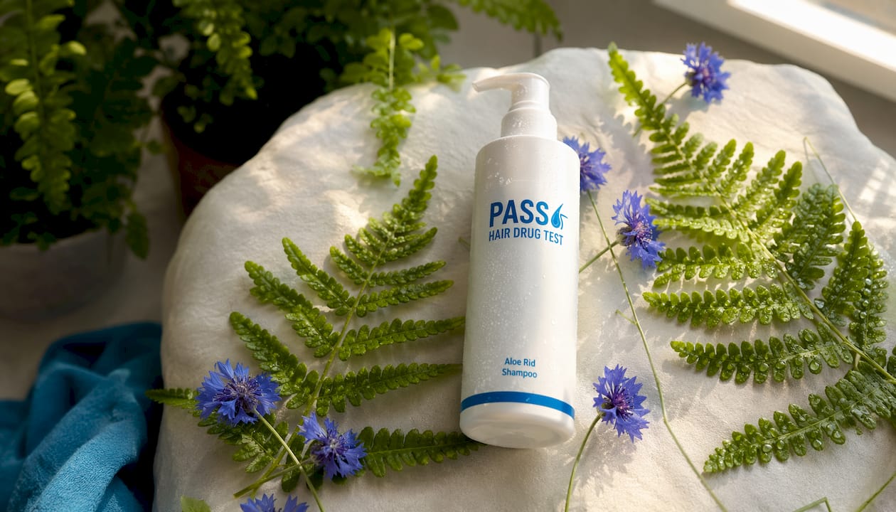 Aloe Rid shampoo bottle with aloe leaves and flowers