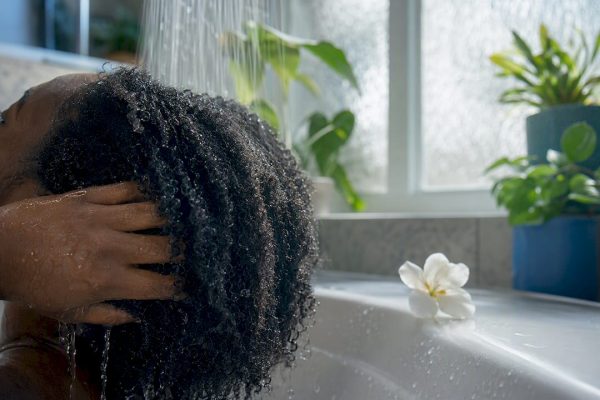 Close-up of wet coiled hair rinsed at sink with leaves