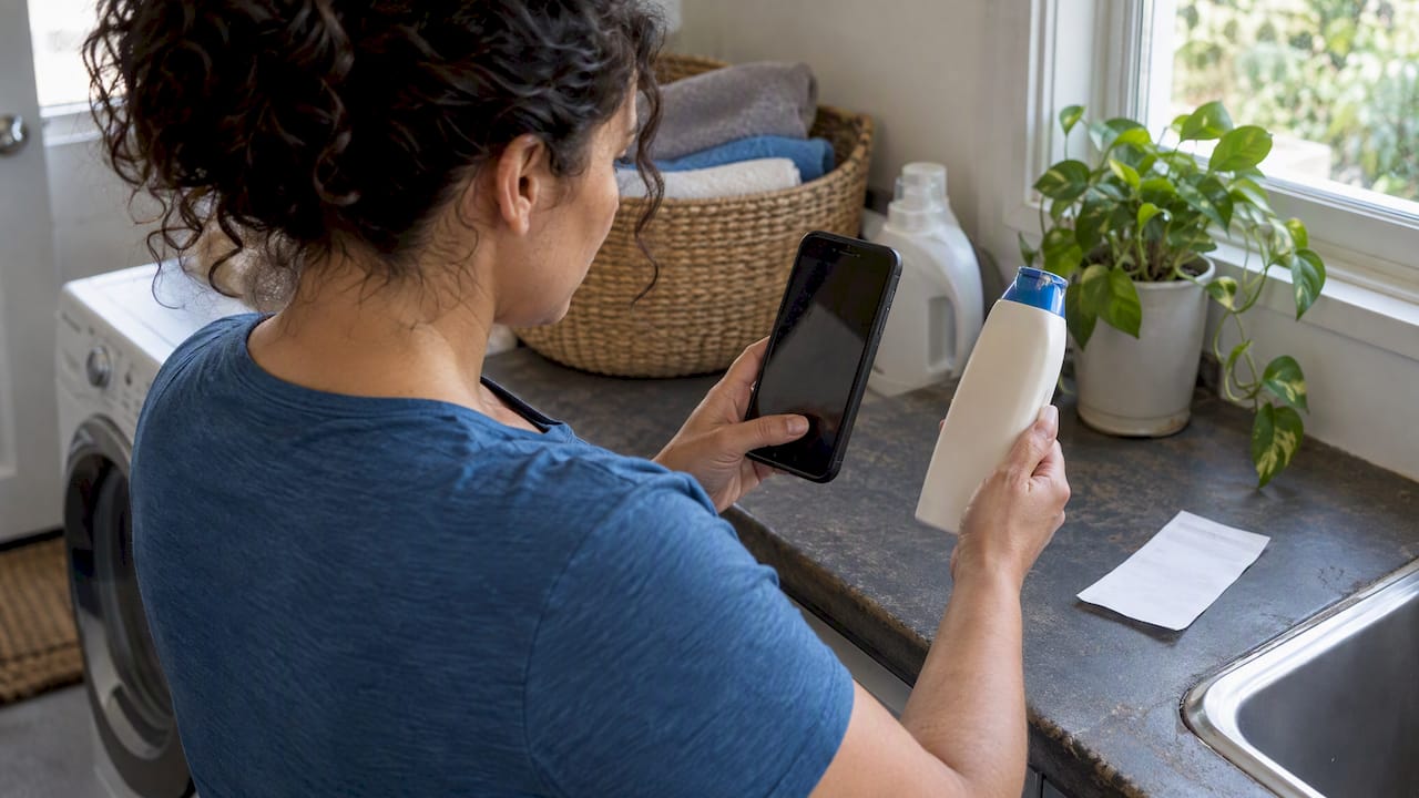 Woman photographing a shampoo bottle seal