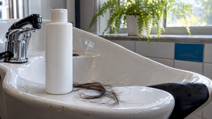Shampoo and hair strands at a wash station