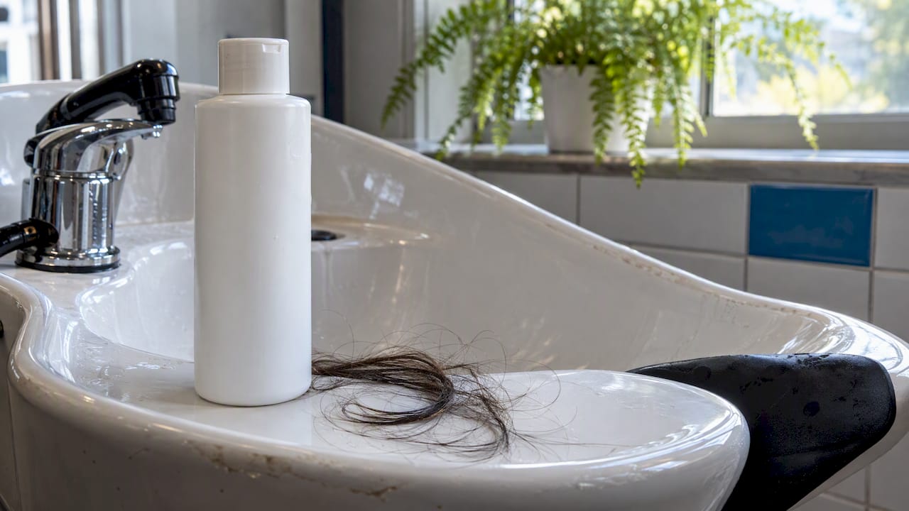 Shampoo and hair strands at a wash station